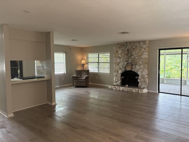 2123 Woodburn Loop S, Lakeland, FL 33813 - unfurnished living room featuring baseboards, a fireplace, healthy amount of natural light, and dark wood finished floors