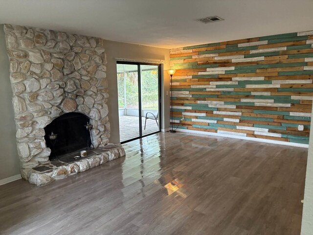2123 Woodburn Loop S, Lakeland, FL 33813 - unfurnished living room with baseboards, wood finished floors, and a stone fireplace
