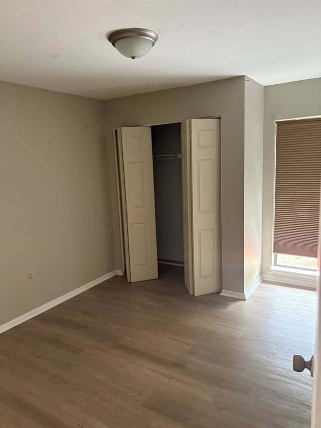 2123 Woodburn Loop S, Lakeland, FL 33813 - unfurnished bedroom featuring wood finished floors, a closet, and baseboards