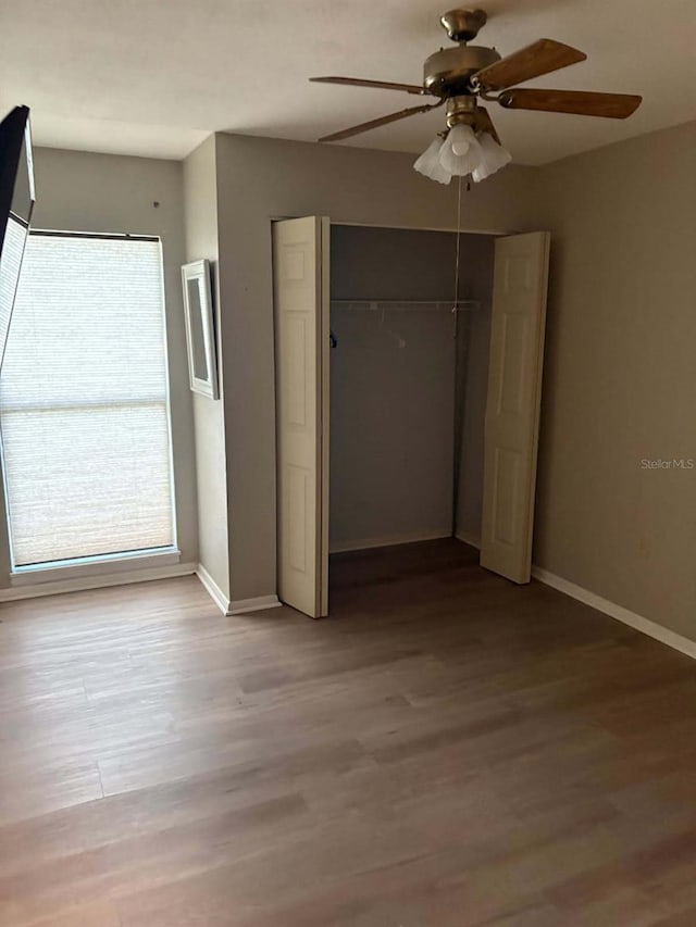 2123 Woodburn Loop S, Lakeland, FL 33813 - unfurnished bedroom featuring a closet, wood finished floors, baseboards, and ceiling fan