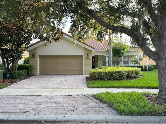 12064 Navale Ln, Orlando, FL 32827 - view of front of home featuring decorative driveway, an attached garage, stucco siding, and a tiled roof