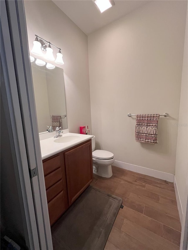 12064 Navale Ln, Orlando, FL 32827 - bathroom featuring vanity, toilet, wood finished floors, and baseboards