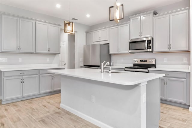 4262 Cloud Hopper Way, Lutz, FL 33559 - kitchen with stainless steel appliances, an island with sink, light countertops, hanging light fixtures, and recessed lighting