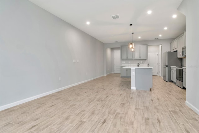 4262 Cloud Hopper Way, Lutz, FL 33559 - kitchen with gray cabinetry, stainless steel appliances, light countertops, light wood-type flooring, and recessed lighting