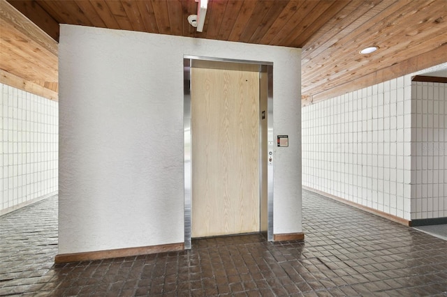 13612 S Village Dr Unit 5201, Tampa, FL 33618 - empty room featuring a textured wall, baseboards, wood ceiling, and elevator