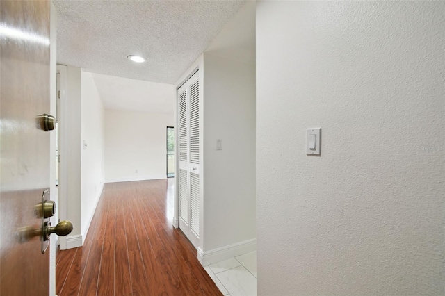 13612 S Village Dr Unit 5201, Tampa, FL 33618 - hall featuring a textured ceiling, baseboards, and wood finished floors