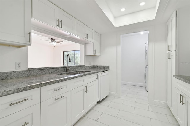 13612 S Village Dr Unit 5201, Tampa, FL 33618 - kitchen with dishwasher, a sink, stacked washing machine and dryer, a ceiling fan, and white cabinetry