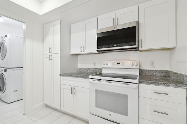 13612 S Village Dr Unit 5201, Tampa, FL 33618 - kitchen featuring stainless steel microwave, white electric range oven, stacked washer and clothes dryer, white cabinets, and dark stone counters