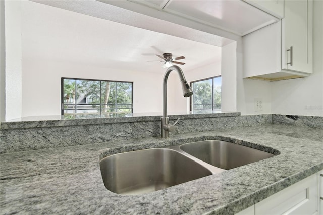 13612 S Village Dr Unit 5201, Tampa, FL 33618 - kitchen view of a sink, light stone counters, white cabinets, and a ceiling fan