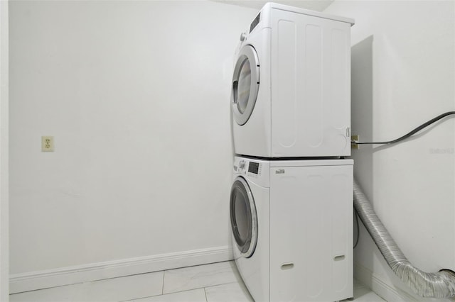 13612 S Village Dr Unit 5201, Tampa, FL 33618 - laundry area with estacked washer and dryer, light marble finish flooring, and baseboards