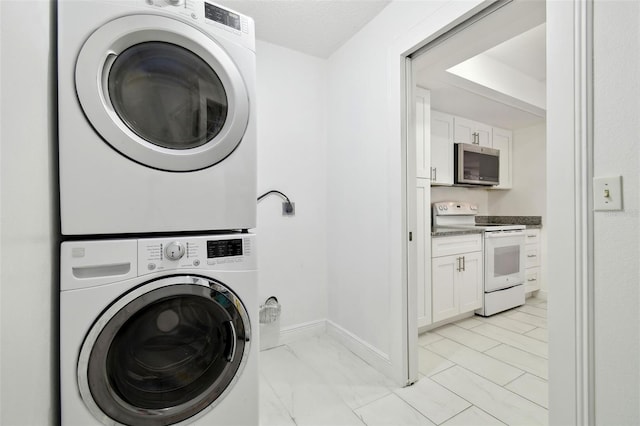 13612 S Village Dr Unit 5201, Tampa, FL 33618 - laundry area featuring stacked washer / dryer, baseboards, and light marble finish floors