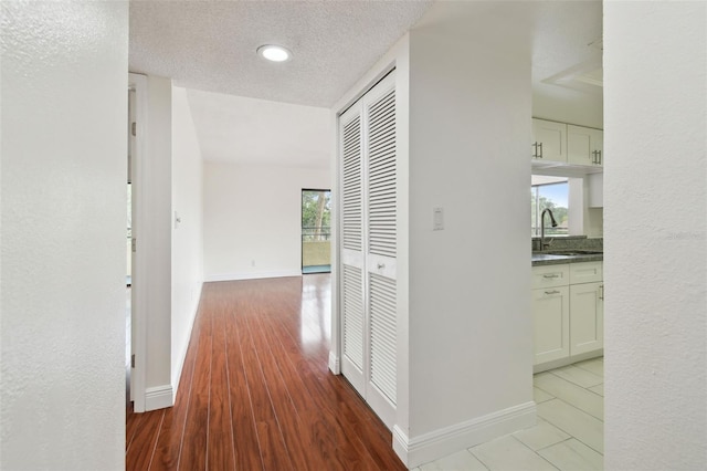 13612 S Village Dr Unit 5201, Tampa, FL 33618 - hallway featuring a sink, baseboards, and a textured ceiling