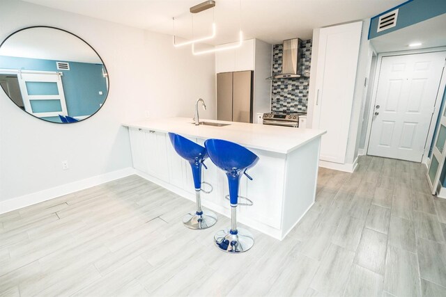 5712 Biscayne Ct Unit 201, New Port Richey, FL 34652 - kitchen featuring wall chimney range hood, a sink, electric range, a peninsula, and light countertops