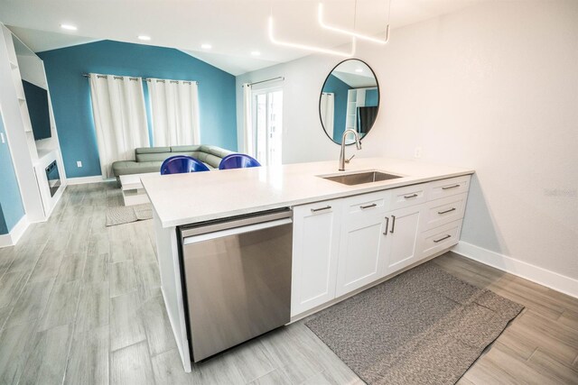 5712 Biscayne Ct Unit 201, New Port Richey, FL 34652 - kitchen featuring stainless steel dishwasher, a sink, a peninsula, white cabinets, and light countertops