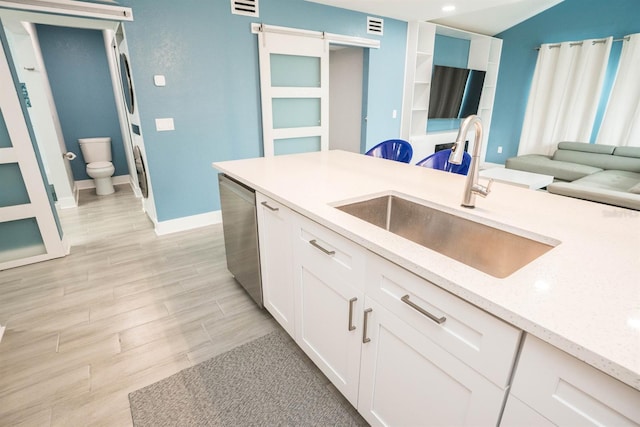 5712 Biscayne Ct Unit 201, New Port Richey, FL 34652 - kitchen with a sink, dishwasher, white cabinets, a barn door, and light wood finished floors