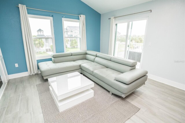 5712 Biscayne Ct Unit 201, New Port Richey, FL 34652 - living area featuring vaulted ceiling, plenty of natural light, baseboards, and wood finished floors