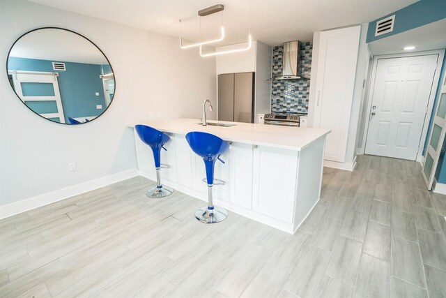 5712 Biscayne Ct Unit 201, New Port Richey, FL 34652 - kitchen featuring wall chimney exhaust hood, a sink, stainless steel electric stove, white cabinets, and a peninsula