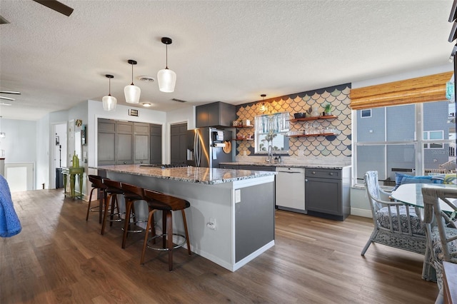 4137 Des Prez Ct, Hernando Beach, FL 34607 - kitchen with stainless steel appliances, open shelves, dark wood-style flooring, a textured ceiling, and a breakfast bar