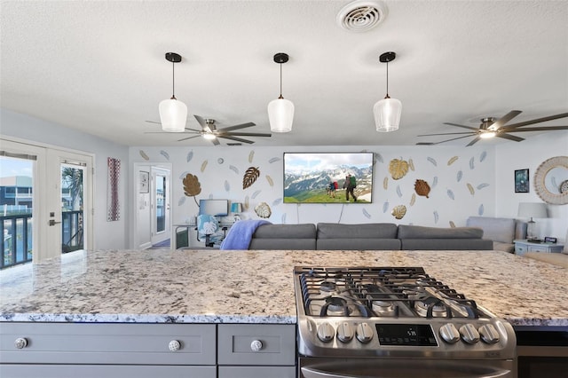 4137 Des Prez Ct, Hernando Beach, FL 34607 - kitchen with a ceiling fan, open floor plan, gas range, wallpapered walls, and light stone countertops