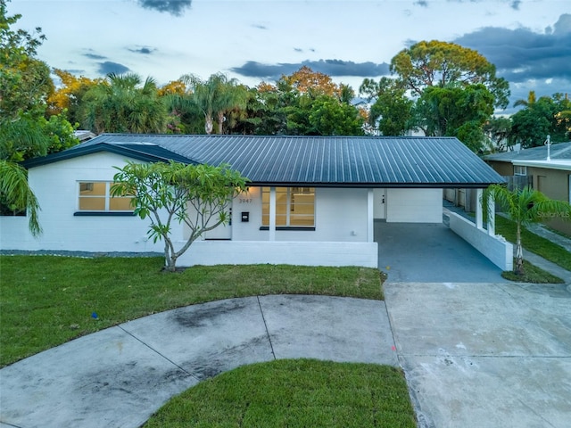 3947 Overlook Dr NE, Saint Petersburg, FL 33703 - single story home with concrete driveway, a front lawn, an attached carport, and metal roof