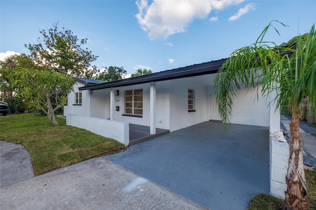 3947 Overlook Dr NE, Saint Petersburg, FL 33703 - view of front of house with a front yard, an attached carport, and concrete driveway