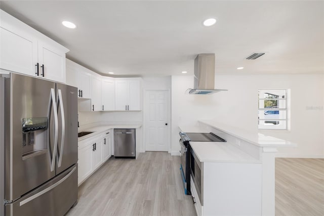 3947 Overlook Dr NE, Saint Petersburg, FL 33703 - kitchen with appliances with stainless steel finishes, island range hood, a peninsula, light countertops, and light wood finished floors