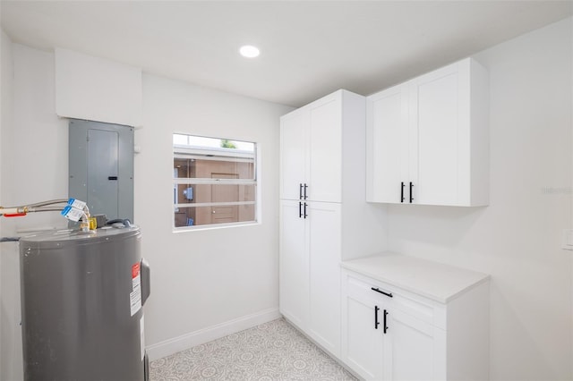 3947 Overlook Dr NE, Saint Petersburg, FL 33703 - kitchen featuring electric panel, water heater, baseboards, white cabinetry, and recessed lighting