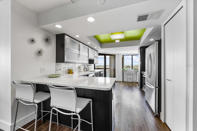 1651 Sand Key Estates Ct Unit 54, Clearwater Beach, FL 33767 - kitchen with freestanding refrigerator, baseboards, a peninsula, dark wood-style floors, and a raised ceiling