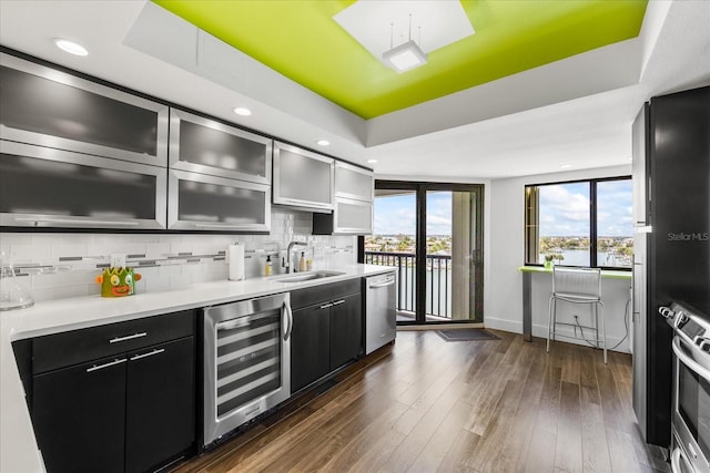 1651 Sand Key Estates Ct Unit 54, Clearwater Beach, FL 33767 - kitchen featuring beverage cooler, a sink, a raised ceiling, dark cabinetry, and recessed lighting