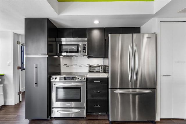 1651 Sand Key Estates Ct Unit 54, Clearwater Beach, FL 33767 - kitchen featuring stainless steel appliances, dark cabinets, backsplash, light countertops, and dark wood-style floors