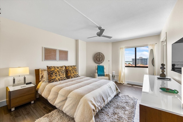 1651 Sand Key Estates Ct Unit 54, Clearwater Beach, FL 33767 - bedroom with dark wood finished floors, a ceiling fan, and baseboards