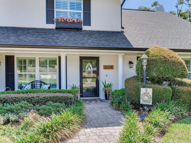 3724 Fawn Grove Ct, Land O Lakes, FL 34639 - view of exterior entry with brick siding, a shingled roof, and covered porch