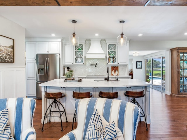 3724 Fawn Grove Ct, Land O Lakes, FL 34639 - kitchen with stainless steel refrigerator with ice dispenser, custom exhaust hood, white cabinets, dark wood-style floors, and a wainscoted wall