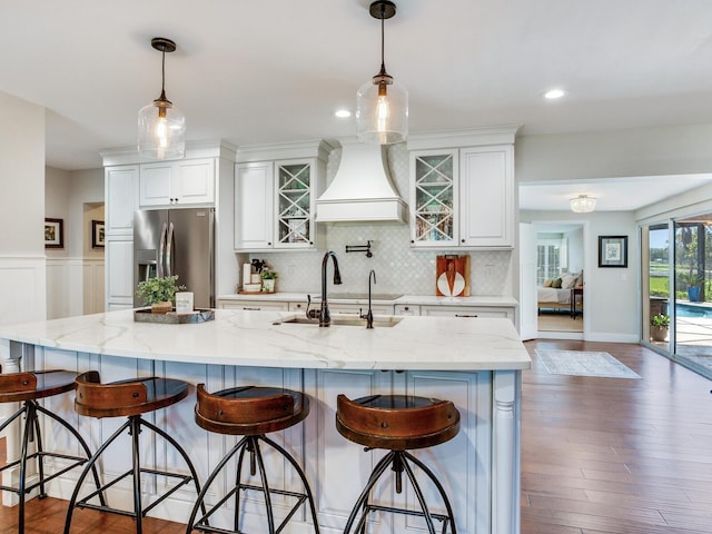 3724 Fawn Grove Ct, Land O Lakes, FL 34639 - kitchen featuring stainless steel fridge with ice dispenser, wall chimney exhaust hood, a sink, white cabinetry, and decorative backsplash
