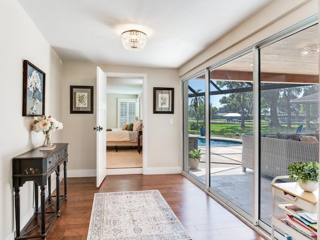 3724 Fawn Grove Ct, Land O Lakes, FL 34639 - entryway featuring baseboards, dark wood-type flooring, a chandelier, and a sunroom