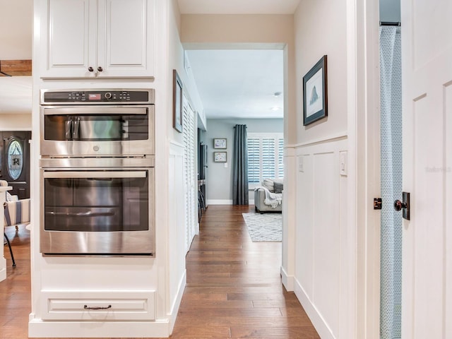 3724 Fawn Grove Ct, Land O Lakes, FL 34639 - kitchen featuring double oven, wood finished floors, white cabinetry, and baseboards