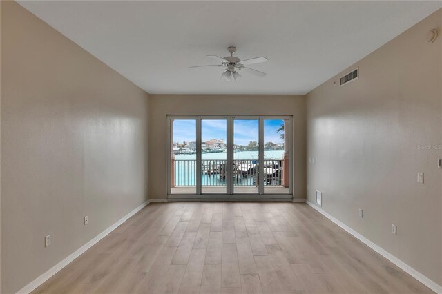 530 S Gulfview Blvd Unit 203, Clearwater Beach, FL 33767 - unfurnished room featuring a ceiling fan, light wood-type flooring, a water view, and baseboards