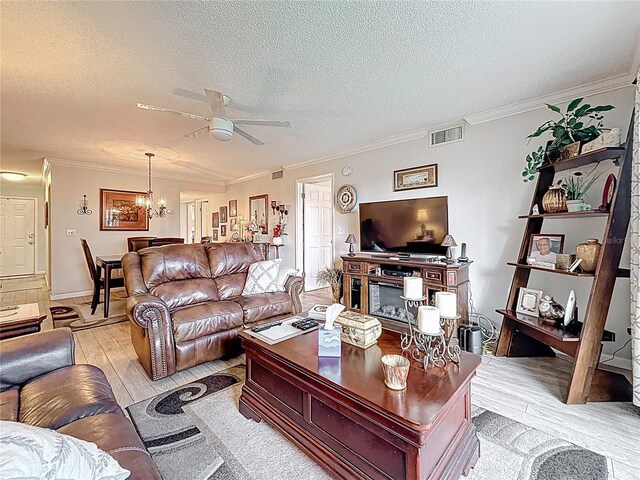 5920 80th St N Unit 406, Saint Petersburg, FL 33709 - living room with light wood finished floors, crown molding, a textured ceiling, a ceiling fan, and a chandelier