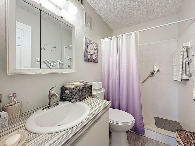 5920 80th St N Unit 406, Saint Petersburg, FL 33709 - bathroom with toilet, a tile shower, a textured ceiling, and vanity