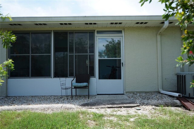 413 Lake Point Ct Unit 4B, Sun City Center, FL 33573 - back of property with stucco siding, cooling unit, and a sunroom