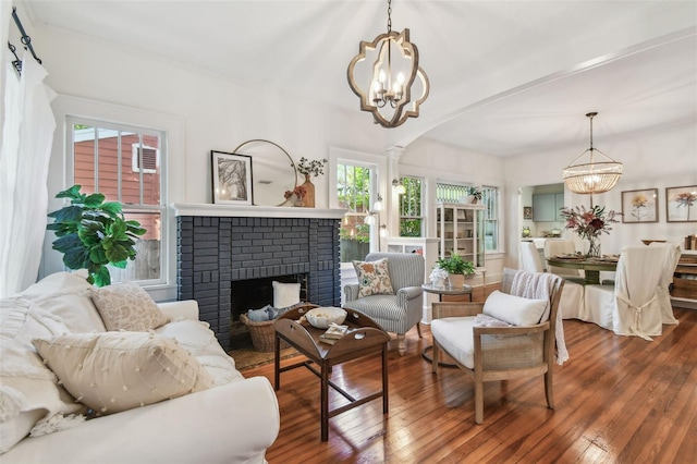 848 9th Ave S, Saint Petersburg, FL 33701 - living room featuring a chandelier, hardwood / wood-style floors, a brick fireplace, and arched walkways