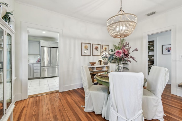 848 9th Ave S, Saint Petersburg, FL 33701 - dining room with a chandelier, ornamental molding, wood finished floors, and baseboards