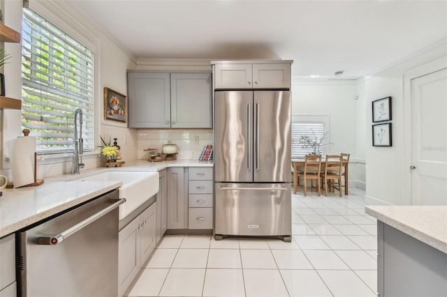 848 9th Ave S, Saint Petersburg, FL 33701 - kitchen featuring stainless steel appliances, gray cabinetry, ornamental molding, light tile patterned flooring, and tasteful backsplash
