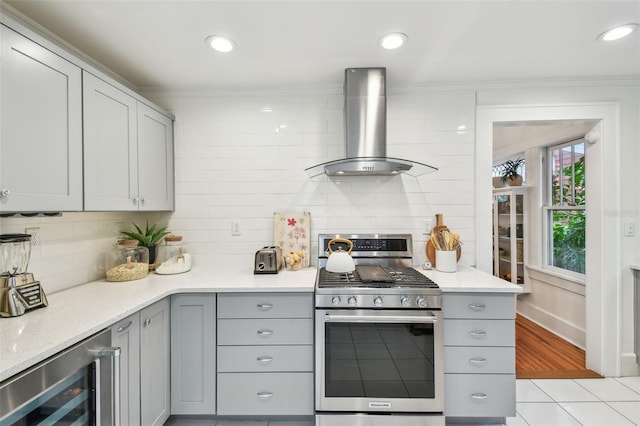 848 9th Ave S, Saint Petersburg, FL 33701 - kitchen with gas range, wine cooler, gray cabinetry, wall chimney exhaust hood, and ornamental molding
