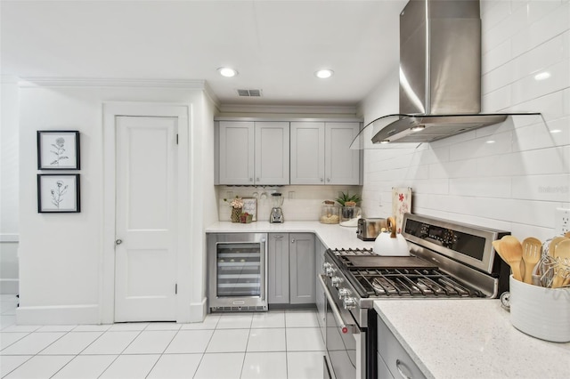 848 9th Ave S, Saint Petersburg, FL 33701 - kitchen featuring stainless steel gas stove, gray cabinets, wine cooler, ventilation hood, and decorative backsplash
