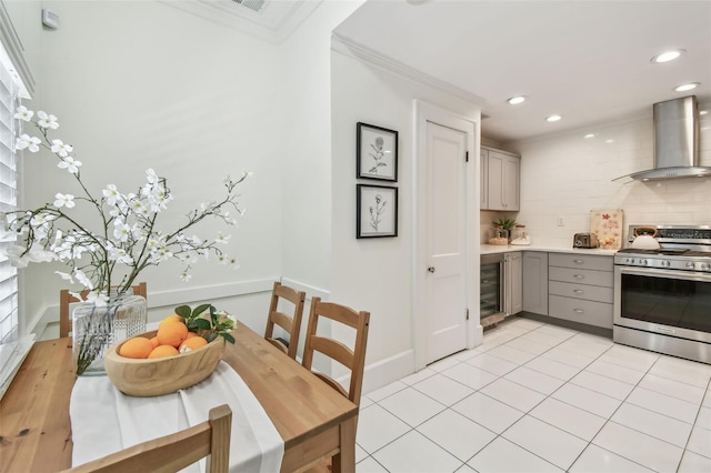848 9th Ave S, Saint Petersburg, FL 33701 - kitchen featuring wall chimney range hood, stainless steel gas range, gray cabinets, backsplash, and beverage cooler