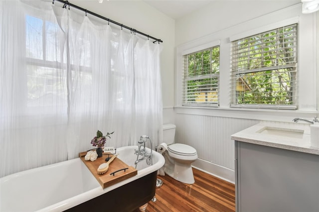 848 9th Ave S, Saint Petersburg, FL 33701 - bathroom featuring a freestanding tub, toilet, wood finished floors, vanity, and wainscoting