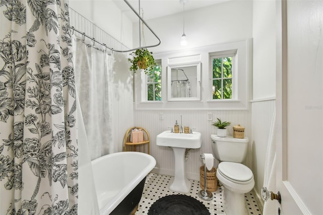 848 9th Ave S, Saint Petersburg, FL 33701 - full bath with wainscoting, a soaking tub, toilet, healthy amount of natural light, and curtained shower