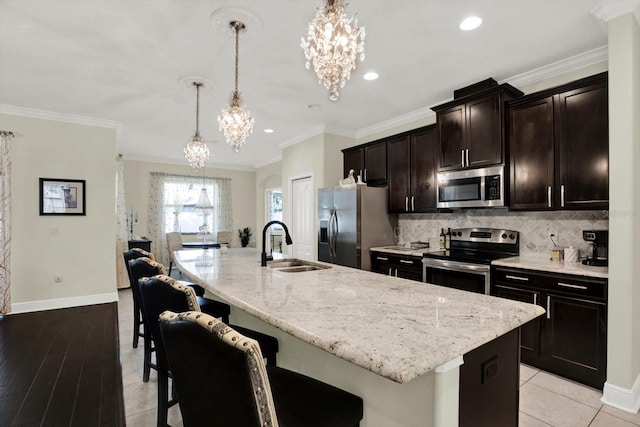 679 Challice Dr, Spring Hill, FL 34609 - kitchen with stainless steel appliances, a chandelier, a sink, decorative backsplash, and a kitchen breakfast bar