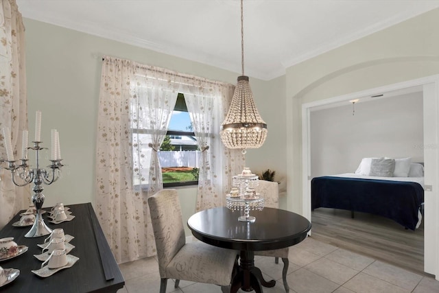 679 Challice Dr, Spring Hill, FL 34609 - dining area with crown molding, light tile patterned flooring, and a chandelier